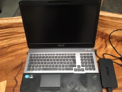 an open laptop computer sitting on top of a wooden table