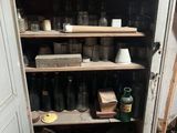 de nombreux bocaux et vases sur les étagères de la pièce