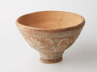 un bol marron posé sur une table, sur fond blanc