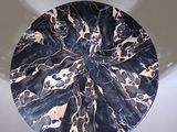 a black and gold marble table with a white base