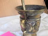 a gold mortar and a pink note on a table