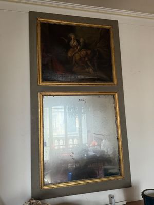 tableau accroché au mur d'un salon, avec un miroir au-dessus