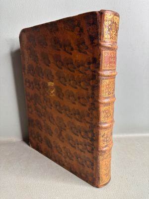 un vieux livre posé sur une table à côté d'un mur