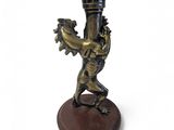 a bronze statue of a man holding a torch in his hand
