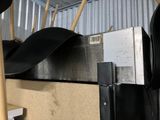 a metal shelf with a bunch of black umbrellas hanging from it