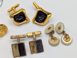 several pairs of gold and black cufflinks and a pair of earrings