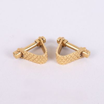 une paire de boucles d'oreilles plaquées or sur fond blanc