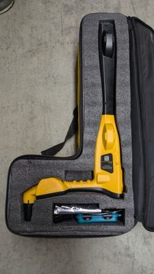 a yellow tool in a black case on the floor