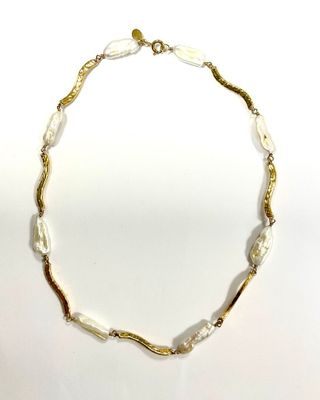 un gros plan d'un collier sur une surface blanche avec un fond blanc