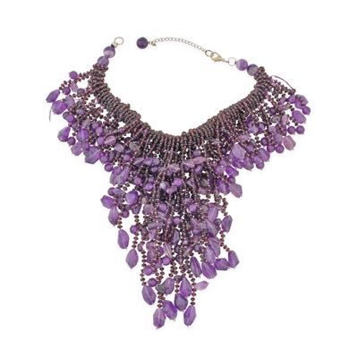 a close up of a purple necklace on a white background