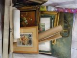 a pile of assorted framed and unframed pictures