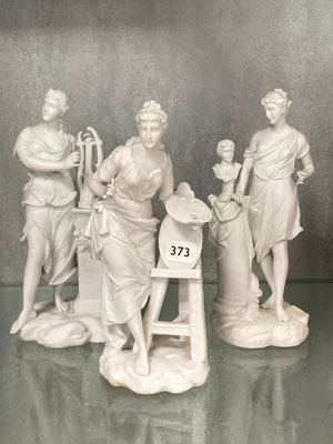 trois figurines posées sur une table en verre