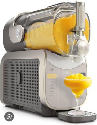 a juicer with a glass of orange juice next to it