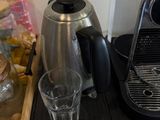 une cafetière et un verre posés sur une table