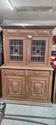 un meuble en bois avec une porte en verre dans une pièce