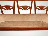 a wooden bench with four wooden chairs on it