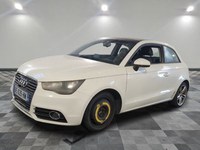 la voiture blanche est garée sur un sol en damier dans le garage