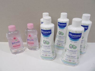 plusieurs flacons de gel hydroalcoolique posés sur un plan de travail blanc