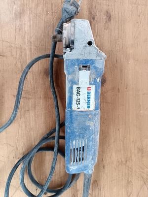 une perceuse électrique bleue posée sur une surface en bois