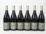six bouteilles de vin sont alignées sur une surface blanche