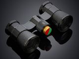 two black binoculars with red and green buttons on a dark surface