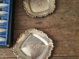 three silver dishes on a wooden table with a blue box