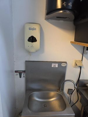 un évier en inox dans un coin d'une petite cuisine