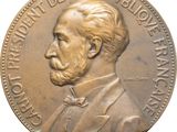 une image représentant une pièce de monnaie en bronze sur laquelle figure le visage d'un homme
