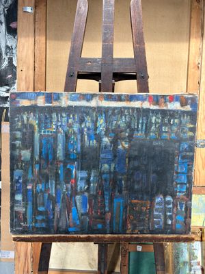 un tableau posé sur un chevalet devant un mur