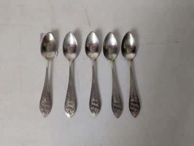 six spoons are lined up in a row on a white surface