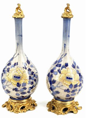 pair of blue and white vases with gold accents on stands
