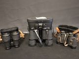 three binoculars and a case are sitting on a table