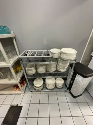 de nombreuses assiettes et bols empilés sur une étagère dans la cuisine