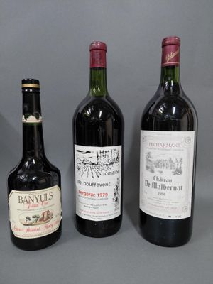 trois bouteilles de vin sont alignées sur une surface grise