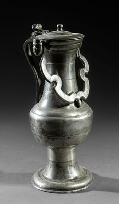 a silver vase that is sitting on a table