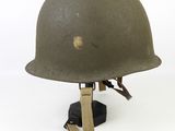 an old army helmet with a wooden stand on a white background