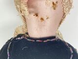a doll with a hat on it ' s head with dirt all over it