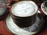 une pile d'assiettes posée sur une table, avec un vase en arrière-plan