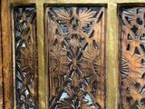 carved wood door with brass frame and glass panels in a room