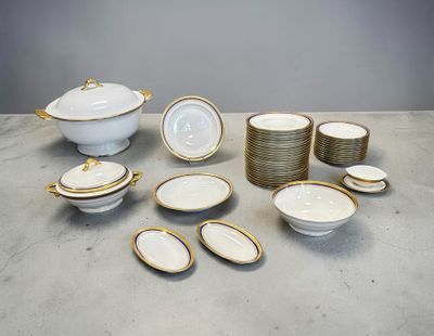 un ensemble d'assiettes et de plats blancs et dorés posés sur une table