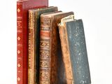 plusieurs vieux livres sont empilés sur une surface blanche
