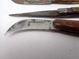 three different types of knives on a white surface