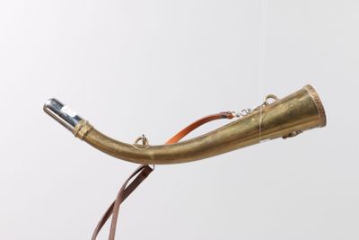 a brass pipe that is connected to a brown cord