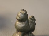 a small statue of a bird sitting on top of a table