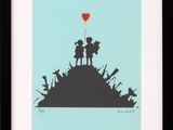 a framed picture of a boy and girl with a heart balloon on top of a hill