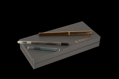 two fountain pens and a box on a black background