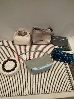 Plusieurs sacs à main et sacs à bandoulière sont disposés sur une table