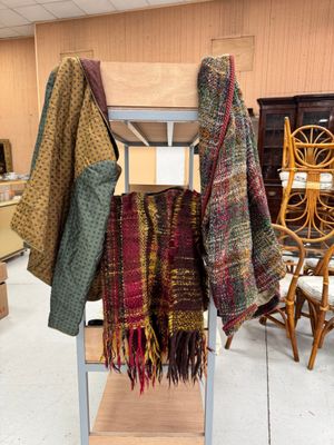 un présentoir sur lequel sont accrochés plusieurs foulards dans un magasin