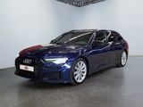 Une Audi bleue est garée dans une grande pièce au plafond noir