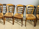six wooden chairs are lined up in a row on a tile floor